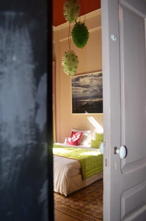 Chambre vue depuis la porte, lustre en grappes de verre vert