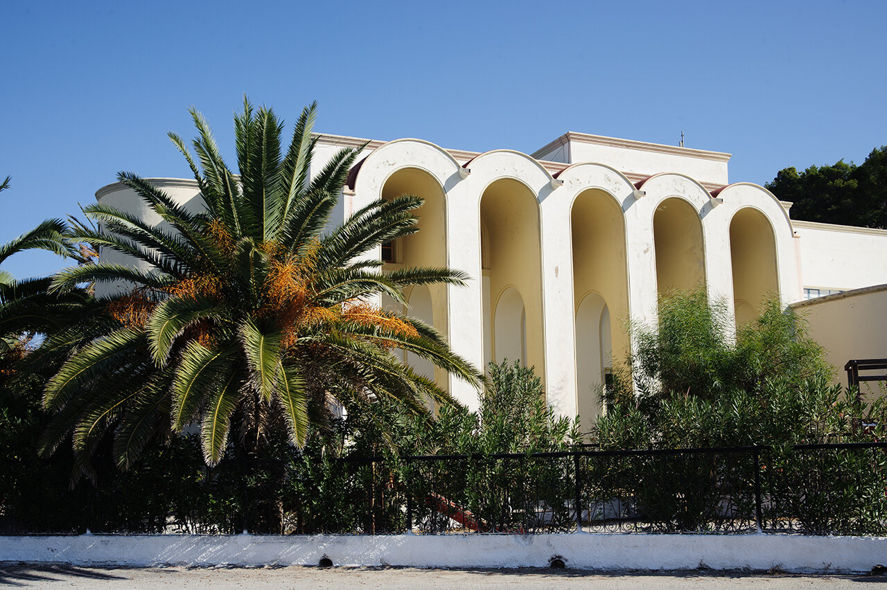 Arcades d'un bâtiment de Lakki et palmier